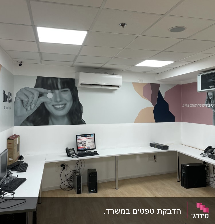 קיר עם עיצוב גרפי צבעוני ודמות אישה מחייכת